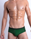 Front view of the CASINO ROYALE (GREEN) Swim Brief, men’s bikini-style bottoms inspired by actor Daniel Craig's iconic blue swim trunks worn in the 2006 film Casino Royale, this brief was designed by BANG! Clothes in Miami.