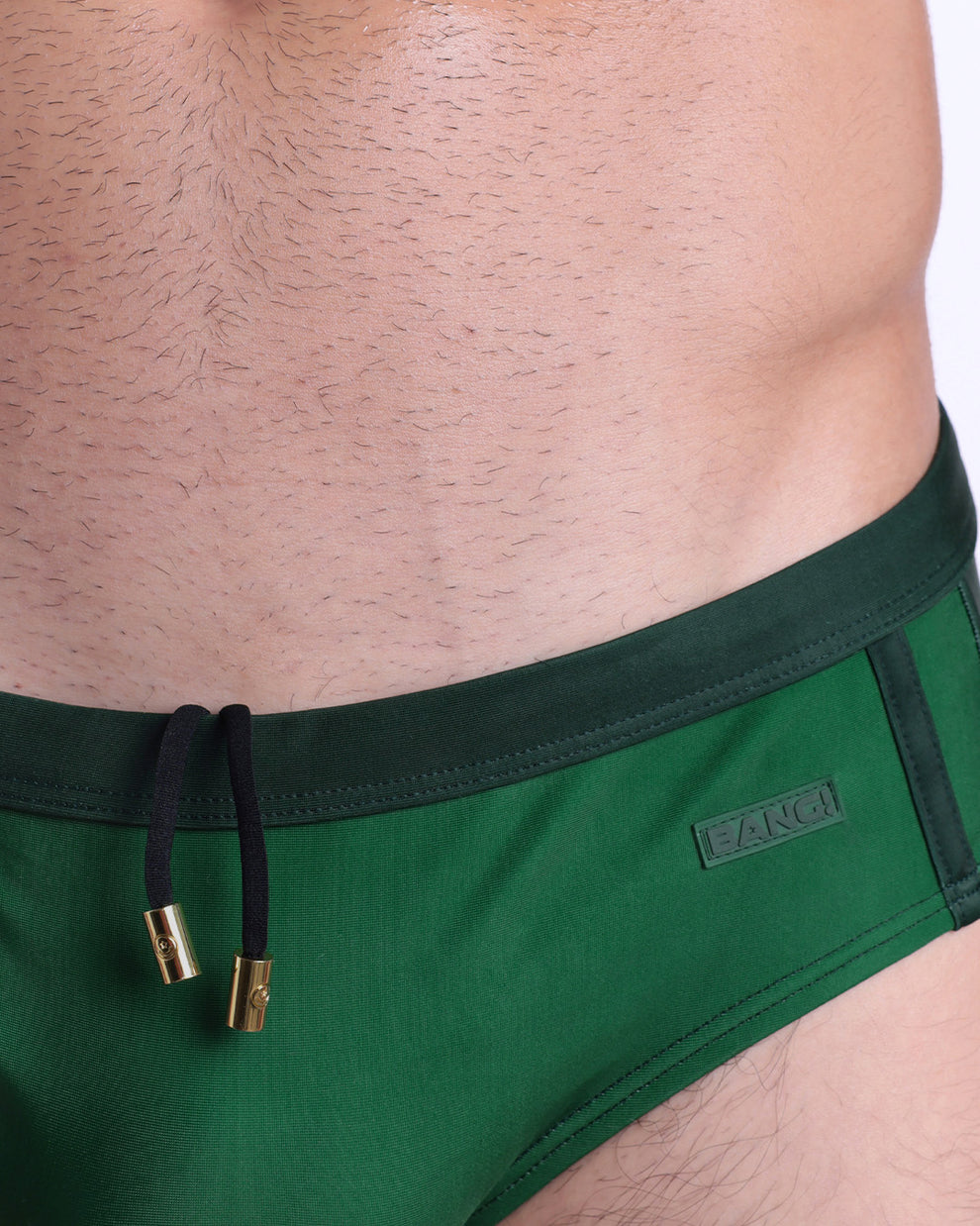 Close-up view of the CASINO ROYALE (GREEN) men’s drawstring briefs showing black cord with custom branded golden cord ends, and matching custom eyelet trims in gold.