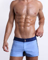 Male model wearing CASINO ROYALE (BLUE), premium men's swimwear with a stylish color block design in dark blue and light blue. These high-quality swimwear bottoms by BANG! Clothes, a men’s beachwear brand from Miami, is inspired by the iconic style of Daniel Craig's blue swim trunks in the 2006 film Casino Royale.