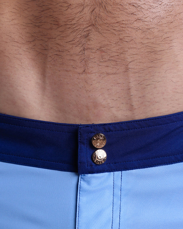 Close-up view of inseam and details of CASINO ROYALE (BLUE) swimsuit for men, showing custom branded golden buttons.