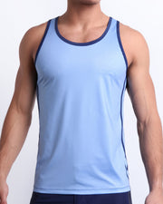 Male model wearing CASINO ROYALE (BLUE) beach Tank Top, premium top with a stylish color block design in dark blue and light blue for men. This high-quality beach top by BANG! Clothes, a men’s beachwear brand from Miami, is inspired by the iconic style of Daniel Craig's blue swim trunks in the 2006 film Casino Royale.