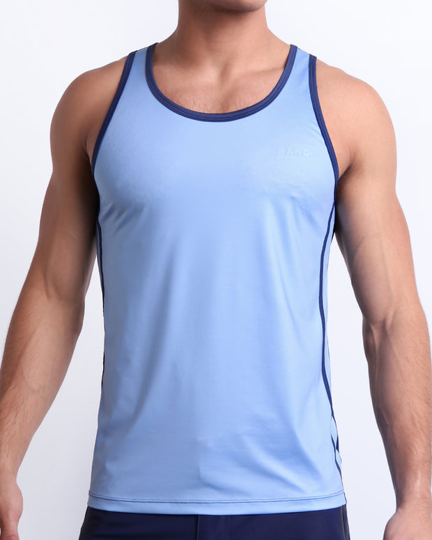 Male model wearing CASINO ROYALE (BLUE) beach Tank Top, premium top with a stylish color block design in dark blue and light blue for men. This high-quality beach top by BANG! Clothes, a men’s beachwear brand from Miami, is inspired by the iconic style of Daniel Craig&