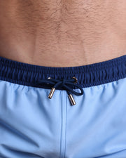 Close-up view of the CASINO ROAYLE (BLUE) men’s summer shorts, showing dark navy blue cord with custom branded golden cord ends, and matching custom eyelet trims in gold.