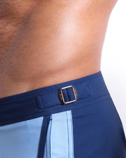 Close-up view of the CASINO ROYALE (BLUE) men’s swimwear, showing custom branded golden adjustable side buckles.