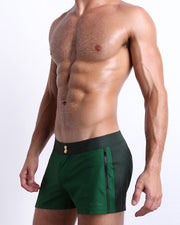 Side view of the CASINO ROYALE (GREEN) for men’s summer Beach Shorts with dual zippered pockets. Inspired by actor Daniel Craig's iconic blue swim trunks worn in the 2006 film Casino Royale, these shorts were designed by BANG! Clothes in Miami.