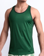 Male model wearing CASINO ROYALE (GREEN) beach Tank Top, premium Summer top with a stylish color block design in dark green and light green for men. This high-quality tank top is by BANG! Clothes, a men’s beachwear brand from Miami, is inspired by the iconic style of Daniel Craig's blue swim trunks in the 2006 film Casino Royale.
