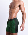 Side view of the CASINO ROYALE (GREEN) for men’s summer Resort Shorts with dual pockets. Inspired by actor Daniel Craig's iconic blue swim trunks worn in the 2006 film Casino Royale, these shorts were designed by BANG! Clothes in Miami.