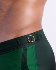 Close-up view of the CASINO ROYALE (GREEN) men’s swimwear, showing custom branded golden adjustable side buckles.