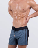 Side view close-up of a male model in the Casino Royale (Grey) Flex Shorts by BANG! Miami. The premium swimwear design features a hybrid waistband, deep zippered pockets, and a flexible, quick-dry fabric for maximum comfort and movement.