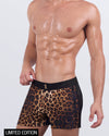 Close-up side view of a male model in the CASINO ROYALE (LEOPARD + BLACK) Beach Shorts for men by BANG! Miami. The premium-quality shorts feature a tapered leg fit, waterproof metallic zip pockets for secure storage, and a four-way stretch fabric that offers flexibility and comfort.