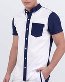 Men's stretch shirt in CASINO ROYALE (WHITE + NAVY BLUE) – a white short-sleeve button-down shirt with navy blue collar, pocket, and sleeves by BANG! Miami. Ideal for resort wear, casual outings, or elevated beach looks.