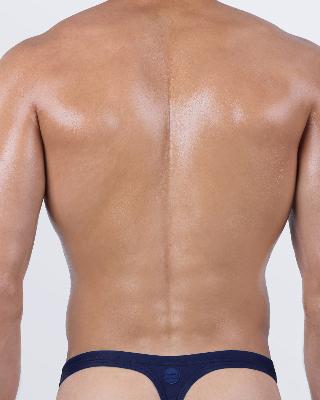 Back view of the CASINO ROYALE Swim Thong – signature “T-back” design in solid navy blue, engineered for comfort and enhanced tan line exposure.
