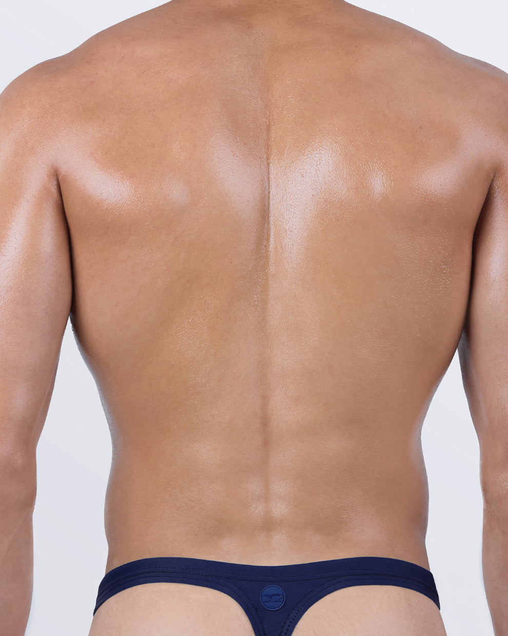 Back view of the CASINO ROYALE Swim Thong – signature “T-back” design in solid navy blue, engineered for comfort and enhanced tan line exposure.