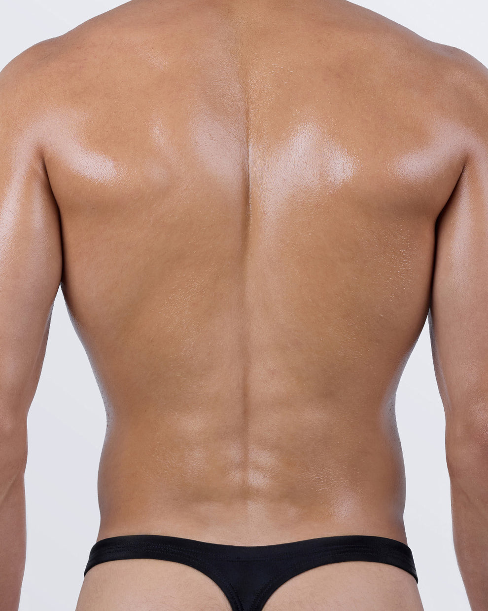 Back view of the Leopard + Black Swim Thong from BANG! – minimalist “T” back cut in solid black for bold tan lines and confident styling.
