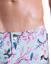 Close-up view of inseam and details of CLOSE TO YOU swimsuit for men, showing custom branded silver buttons.