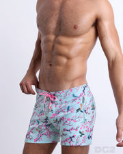Side view of the CLOSE TO YOU men’s summer Flex Shorts, with dual zippered pockets. The shorts have a stylish exotic birds design in a light blue color with pink flowers for men. These high-quality swimwear bottoms by DC2, a men’s beachwear brand from Miami.