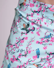 Close-up view of the CLOSE TO YOU men’s Flex Shorts with pink flowers and branches birds print, showing custom branded silver zippered pockets.
