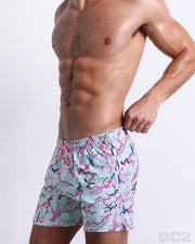 Side view of the CLOSE TO YOU for men’s summer Resort Shorts with dual zippered pockets. Inspired by exotic birds on top of branches and pink flowers, these shorts were designed by DC2 in Miami.