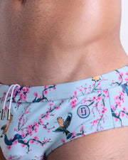 Close-up view of the CLOSE TO YOU men’s drawstring briefs showing white cord with custom branded metallic silver cord ends, and matching custom eyelet trims in silver.