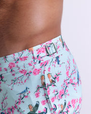 Close-up view of the CLOSE TO YOU men’s swimwear, showing custom branded silver metal adjustable side buckles.