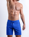 Frontal view of sexy model wearing the CLUB BLUE men’s all-purpose swimwear bottoms in a royal blue color by the Bang! brand of men's beachwear from Miami.