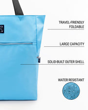 Infographic highlighting the key features of the COASTAL BLUE Poolside Tote Bag by DC2 Miami. The image showcases the bag's solid light sky blue color and points out its travel-friendly foldable nature, large capacity, solid-built outer shell, and water-resistant material. A close-up of water droplets on the fabric illustrates the water resistance of the bag.