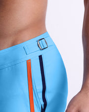 Close-up view of the COASTAL BLUE men’s swimwear, showing custom-branded silver adjustable side buckles.