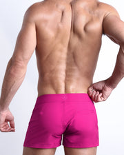 Back view of the CONFESS MAGENTA beach trunks in a fuschia pink color for men by BANG! menswear Miami.
