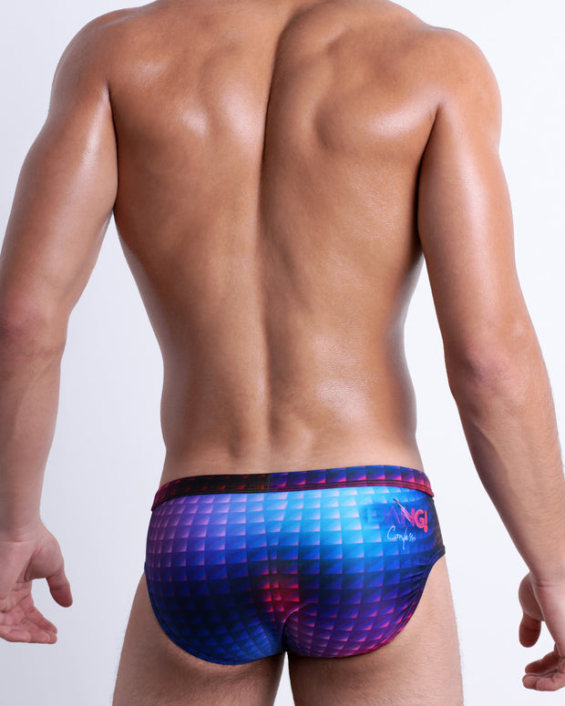 Back view of a model wearing CONFESSIONS ON A SAND FLR VOL 2 men’s beach brief in a multi color disco ball insapired by Madonna, Abba, and Studio 54 made by the Bang! Miami official brand of men&