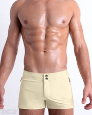 Front view of a male model wearing the men’s CREAM FIELDS Beach Shorts, in a pale yellow color for men. These premium quality swimwear bottoms are by DC2 a capsule brand from BANG! Clothes, a men’s beachwear brand from Miami.