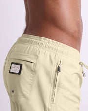 Side view of the CREAM FIELDS for men’s summer Resort Shorts with dual zippered pockets in a solid light pale yellow color designed by DC2 a brand based in Miami.