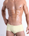 Front view of model wearing the CREAM FIELDS men’s Swim Sunga in a solid light pastel yellow color by DC2, a men's beachwear brand from Miami.