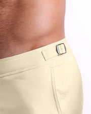 Close-up view of the CREAM FIELDS men’s swimwear, showing custom branded silver metal adjustable side buckles.