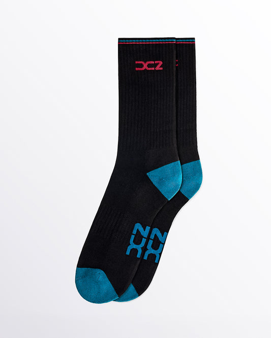 DC2 Daily Ribbed Crew Socks (Black + Teal) — pair of mid-calf socks with teal toe/heel, red DC2 logo, and teal/red cuff stripe.