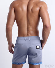 Back view of a model wearing woven twill cotton chino shorts in a light gray color for men. These premium quality swimwear bottoms are DC2 by BANG! Clothes, a men’s beachwear brand from Miami.