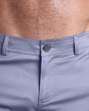 Close up view of cotton fabric chino street shorts with custom engraved front tack button in a silver finish by DC2 men's clothing brand.