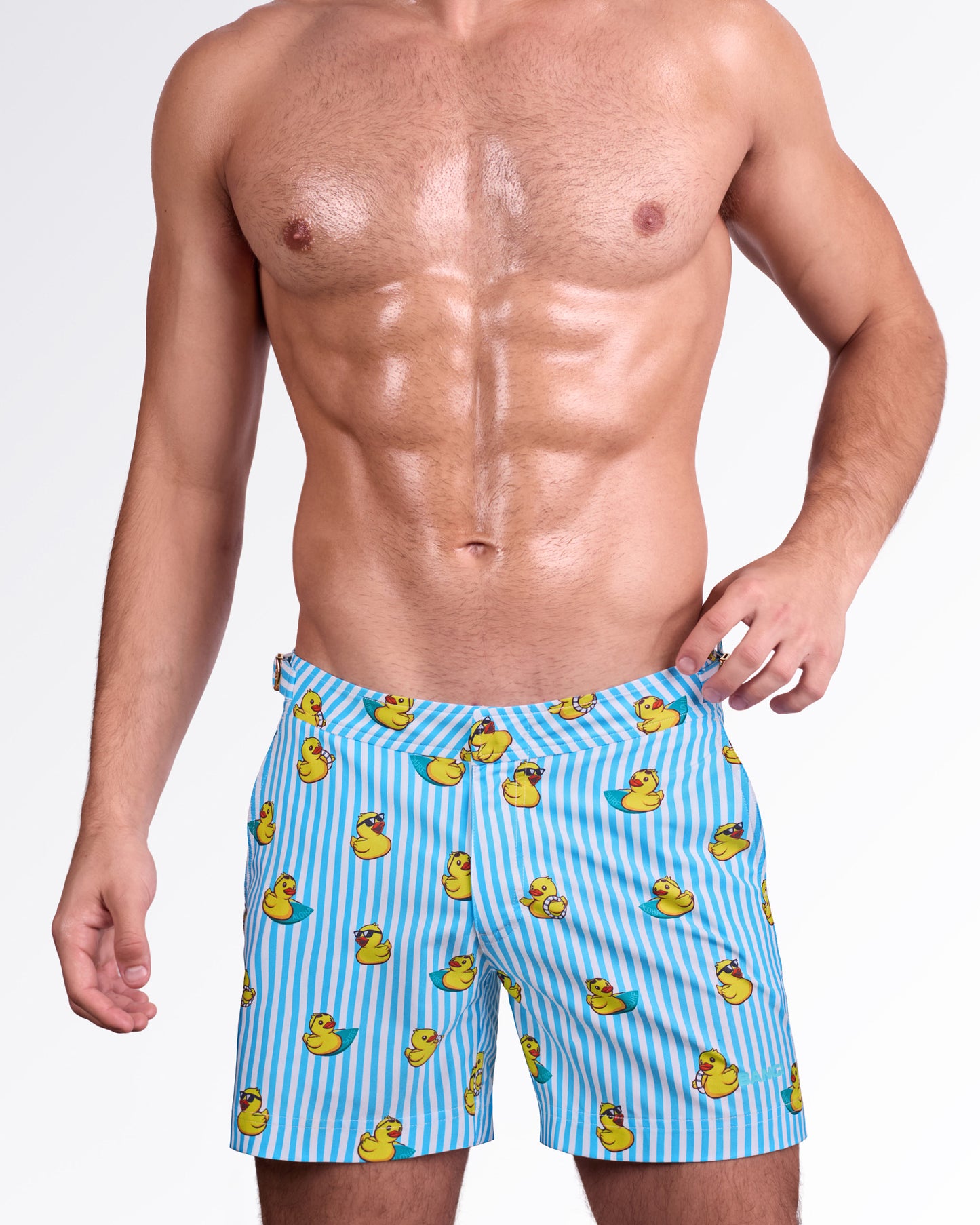 BANG! Miami Ducks Just Wanna Have Fun Tailored Shorts — model wearing men’s tailored swim shorts in blue and white stripe print with yellow duck graphics, featuring adjustable side tabs and structured waistband.