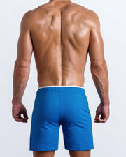 Back view of the men's above-knees length fitness workout shorts in a solid bright blue color by BANG! menswear Miami.