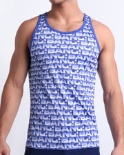 Male model wearing ESCAPADE (BLUE/WHITE) beach Tank Top, premium swimwear with a stylish blue and white graphic monogram print for men. This high-quality Summer top by BANG! Clothes, a men’s beachwear brand from Miami.