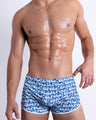 Front view of ESCAPADE (BLUE/WHITE) men’s sexy bottoms features a monogram print in blue and white colors. This premium quality swimwear is by BANG! Clothes, a men’s beachwear brand from Miami.