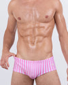 Model wearing FAST LINES (CHILL PINK) Swim Sunga – front view. Featuring vertical pastel pink and white stripes in a Brazilian-inspired silhouette that sits mid-rise on the waist for a flattering and secure fit.