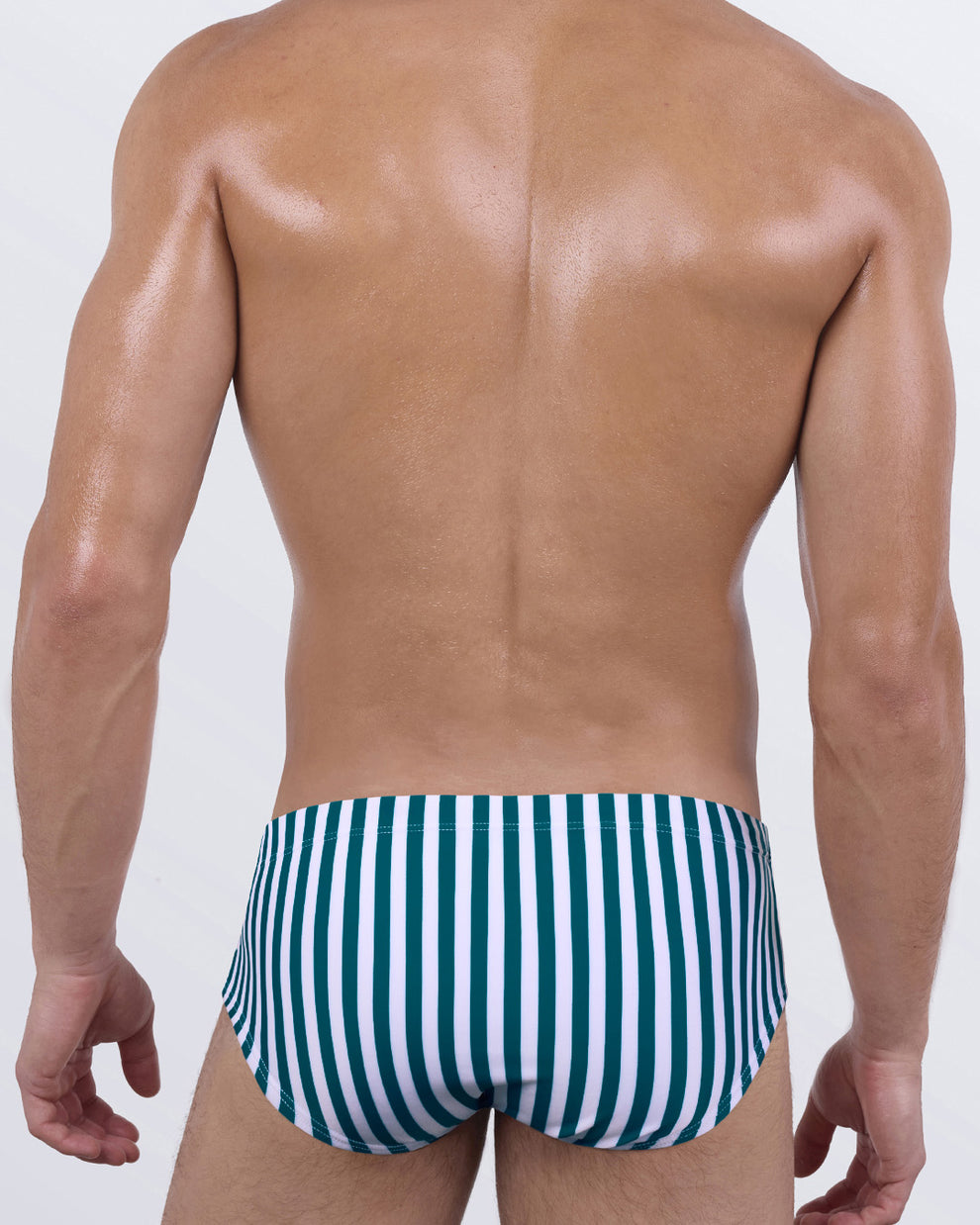 Back view of FAST LINES (PACIFIC GREEN) men’s swim sunga highlighting the snug mid-length waist coverage and sleek fit. Clean design and body-contouring stripes that emphasize movement and form.