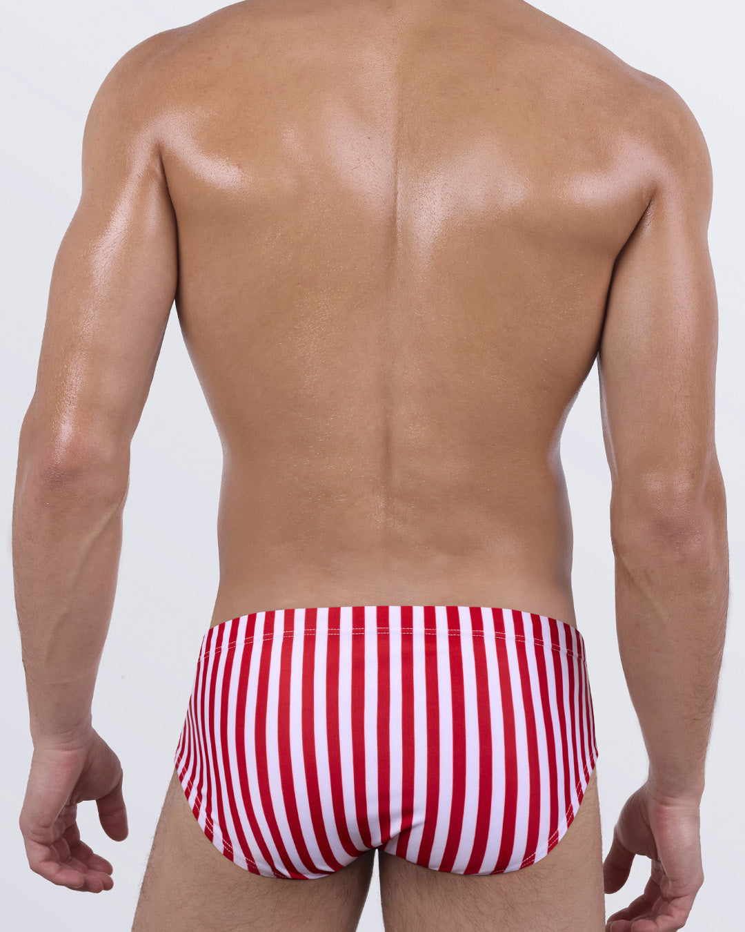 Back view of FAST LINES (RAPID RED) men’s swim sunga showing seamless support and vibrant candy-striped design in red and white. Clean-lined fit ideal for pool or beach days.