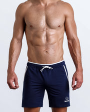 Frontal view of male model wearing the FIT BLUE athletic crossfit gym shorts in a solid blue color by the Bang! brand of men's beachwear from Miami.