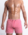 Frontal view of male model wearing the FLAMINGO PINK 2-in-1 Endurance Shorts in a solid pink quick-dry by DC2 brand of men's beachwear from Miami.