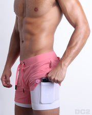 Side view of men’s triaining  in a solid pink color with interior compression phone pocket made made by DC2 the official brand of mens sportswear.