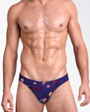 DC2 Flower Powers Blue Swim Mini Brief — model wearing navy floral men’s swimwear with multicolor hibiscus print and low-rise tailored fit.
