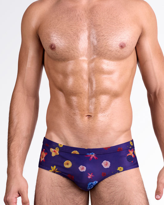 DC2 Flower Powers Blue Swim Brief — front view featuring deep blue base with multicolor floral print, low-rise tailored fit and smooth waistband finish.