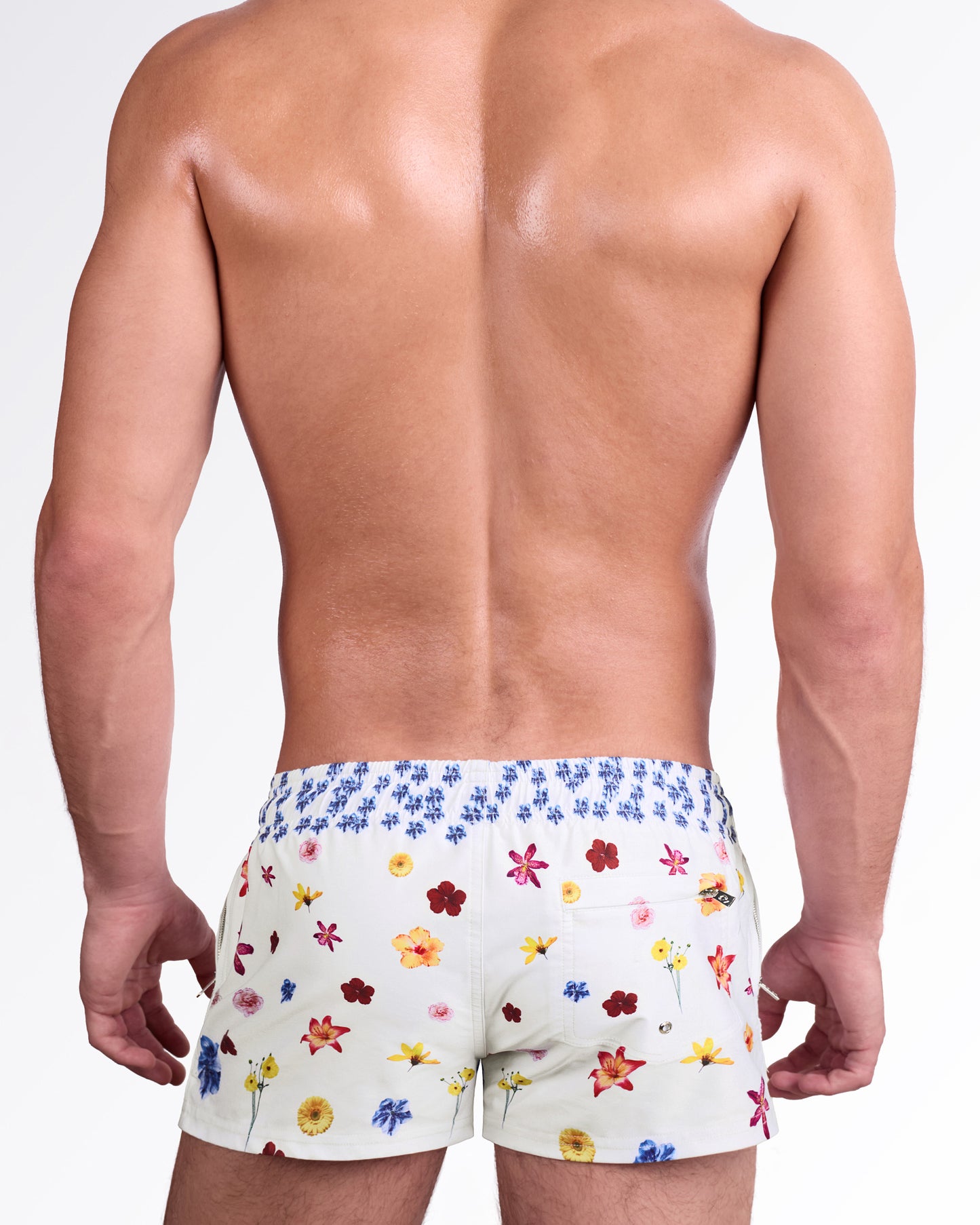 DC2 Flower Powers (Cream) Poolside Shorts — model wearing cream-colored poolside swim shorts featuring a vibrant scattered floral print, adjustable drawstring waistband, and modern short-length beach silhouette.