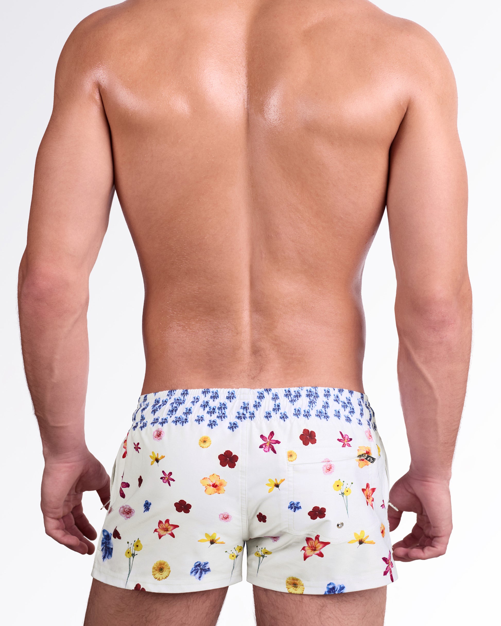 DC2 Flower Powers (Cream) Poolside Shorts — model wearing cream-colored poolside swim shorts featuring a vibrant scattered floral print, adjustable drawstring waistband, and modern short-length beach silhouette.